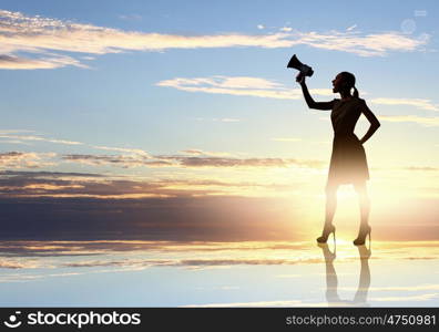 Woman with megaphone. Silhouette of woman at sunset screaming in megaphone