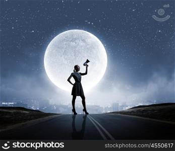 Woman with megaphone. Silhouette of woman on road and screaming in megaphone