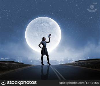 Woman with megaphone. Silhouette of woman on road and screaming in megaphone
