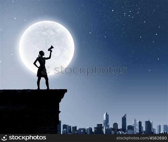 Woman with megaphone. Silhouette of woman on top of building and screaming in megaphone
