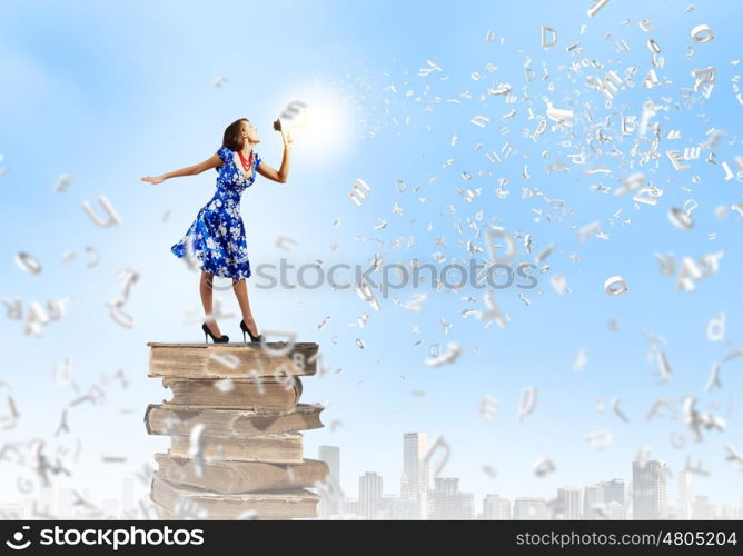 Woman with megaphone. Young woman in blue dress talking in megaphone