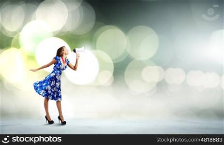Woman with megaphone. Young woman in blue dress talking in megaphone