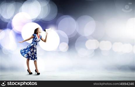 Woman with megaphone. Young woman in blue dress talking in megaphone