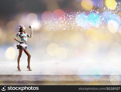 Woman with megaphone. Young woman in colored dress speaking in megaphone