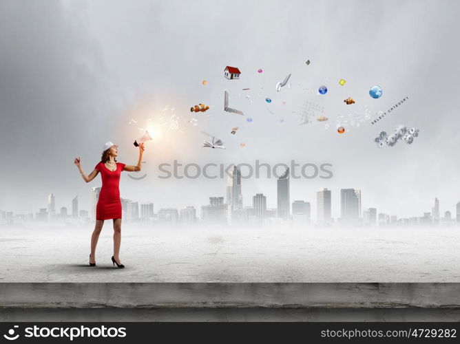 Woman with megaphone. Young woman in red dress speaking in megaphone