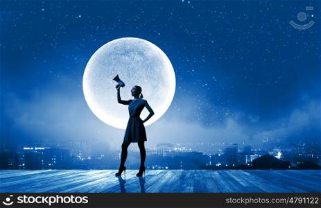 Woman with megaphone. Young woman speaking in megaphone against full moon
