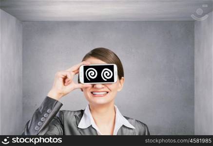 Woman with mobile phone. Beautiful young woman holding mobile phone against her eyes