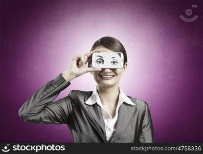 Woman with mobile phone. Beautiful young woman holding mobile phone against her eyes