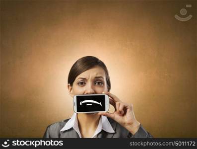 Woman with mobile phone. Beautiful young woman holding mobile phone against her mouth and smiling