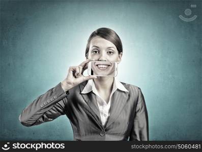 Woman with mobile phone. Beautiful young woman holding mobile phone against her mouth and smiling