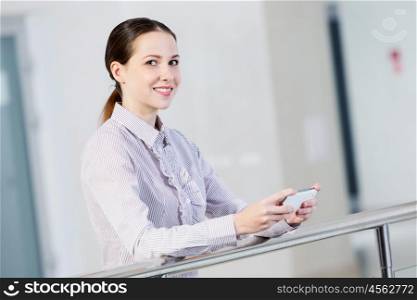 Woman with mobile phone. Woman standing at balcony and sending text from her mobile phone