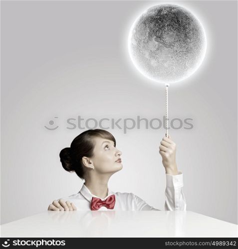 Woman with moon. Young woman holding balloon colored like moon planet