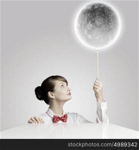 Woman with moon. Young woman holding balloon colored like moon planet