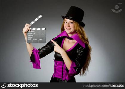 Woman with movie clapboard against grey background