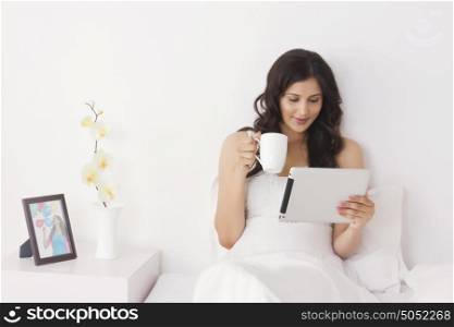 Woman with mug of tea and digital tablet