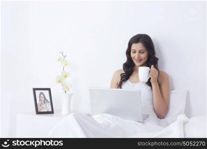 Woman with mug of tea and laptop