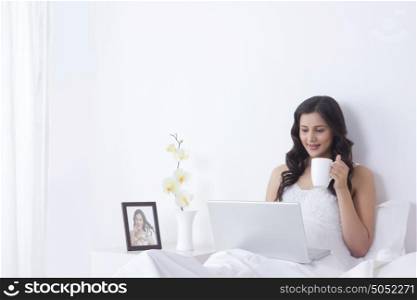 Woman with mug of tea and laptop