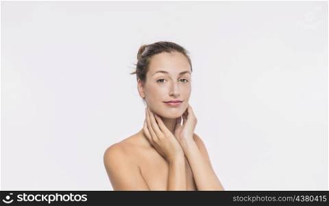 woman with naked shoulders touching neck