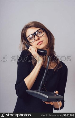 Woman with office or home phone. On a gray background.