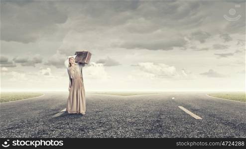 Woman with old suitcase. Beautiful woman with retro suitcase walking on road