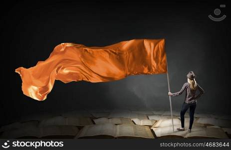 Woman with orange waving flag. Student girl in casual with orange flag in hands