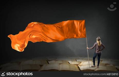 Woman with orange waving flag. Student girl in casual with orange flag in hands