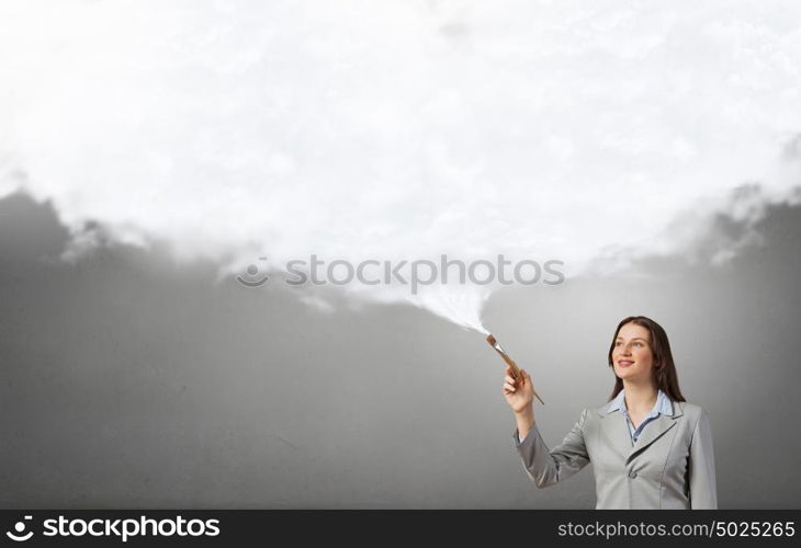 Woman with paint brush. Young pretty businesswoman holding paint brush. Creativity concept