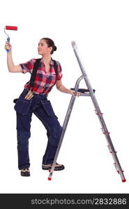 Woman with paint roller stood by ladder