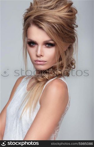 Woman with perfect skin wearing smoky make-up and hairstyle.