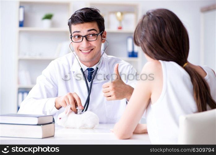 Woman with pet rabbit visiting vet doctor