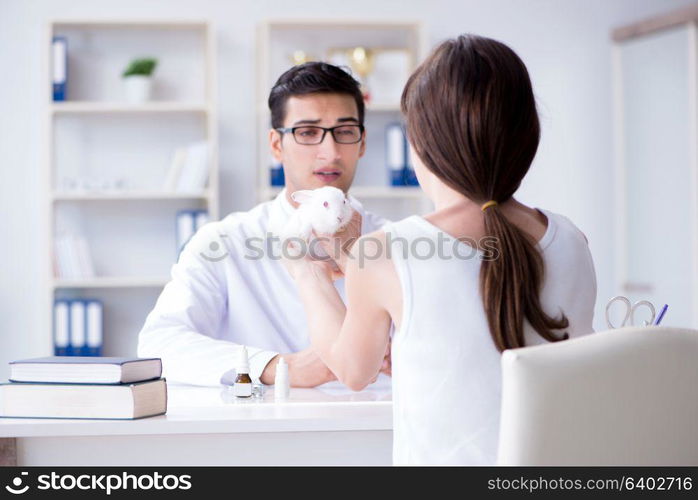 Woman with pet rabbit visiting vet doctor