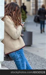 Woman with phone in hand. Phone texting. Side view. Real people. Unrecognizeable