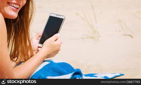 Woman with phone on beach. Technological resting