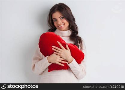 Woman with pillow heart. Beautiful woman with red pillow heart, valentine&rsquo;s day concept