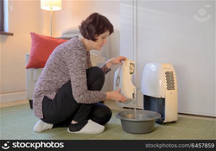 Woman with Portable dehumidifier colect water