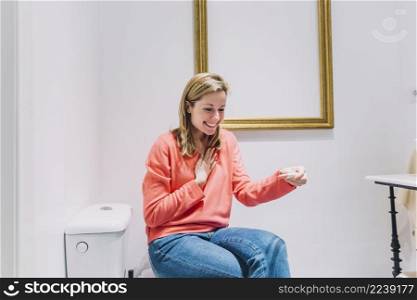 woman with pregnancy test toilet