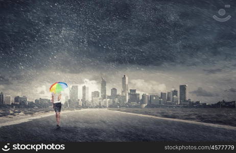 Woman with rainbow umbrella. Young pretty businesswoman with rainbow colorful umbrella walking in storm