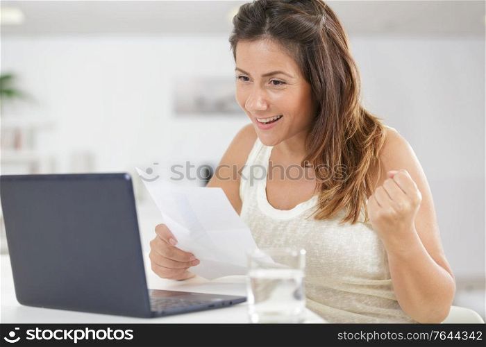 woman with raised hands relaxing with laptop computer