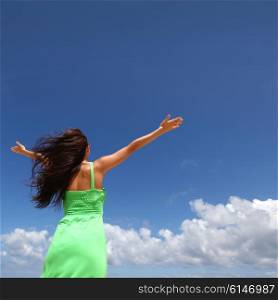 Woman with raised hands. Woman with raised hands over blue sky background