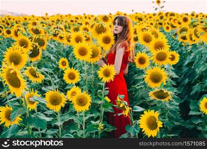 woman with red dress in sunflowers field.. woman with red dress in sunflowers field