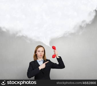 Woman with red handset. Portrait of young businesswoman with red phone receiver in hands