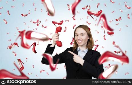 Woman with red handset. Portrait of young businesswoman with red phone receiver in hands
