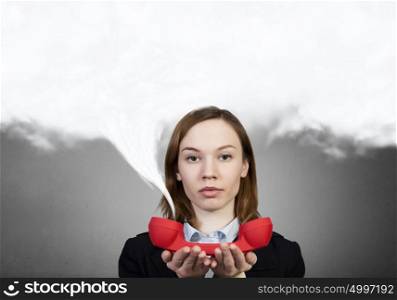 Woman with red handset. Portrait of young businesswoman with red phone receiver in hands