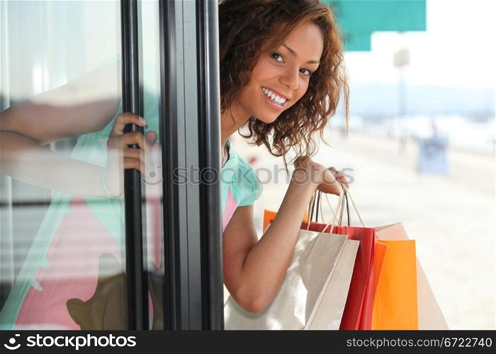 Woman with shopping bags coming out of shop