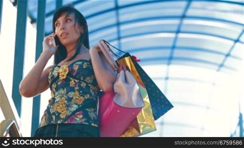 Woman with shopping bags converse with excitement on a city street