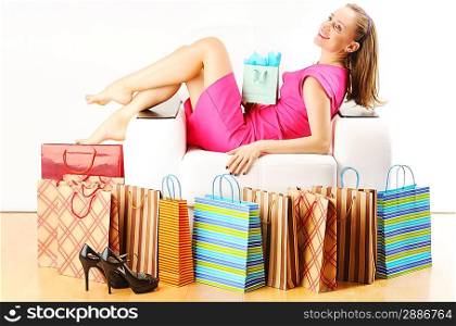 Woman with shopping bags having a rest on sofa