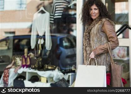 woman with shopping bags walking boutique