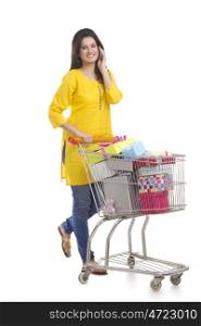 Woman with shopping cart talking on a mobile phone