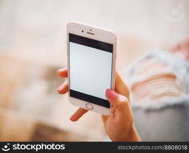 Woman with smartphone at home, white screen. Hands of young girl with flash tattoo using mobile device. High quality photo. Woman with smartphone at home, white screen. Hands of young girl with flash tattoo using mobile device.