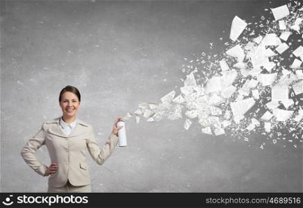 Woman with spray can. Young woman in suit with suitcase spraying paper sheets